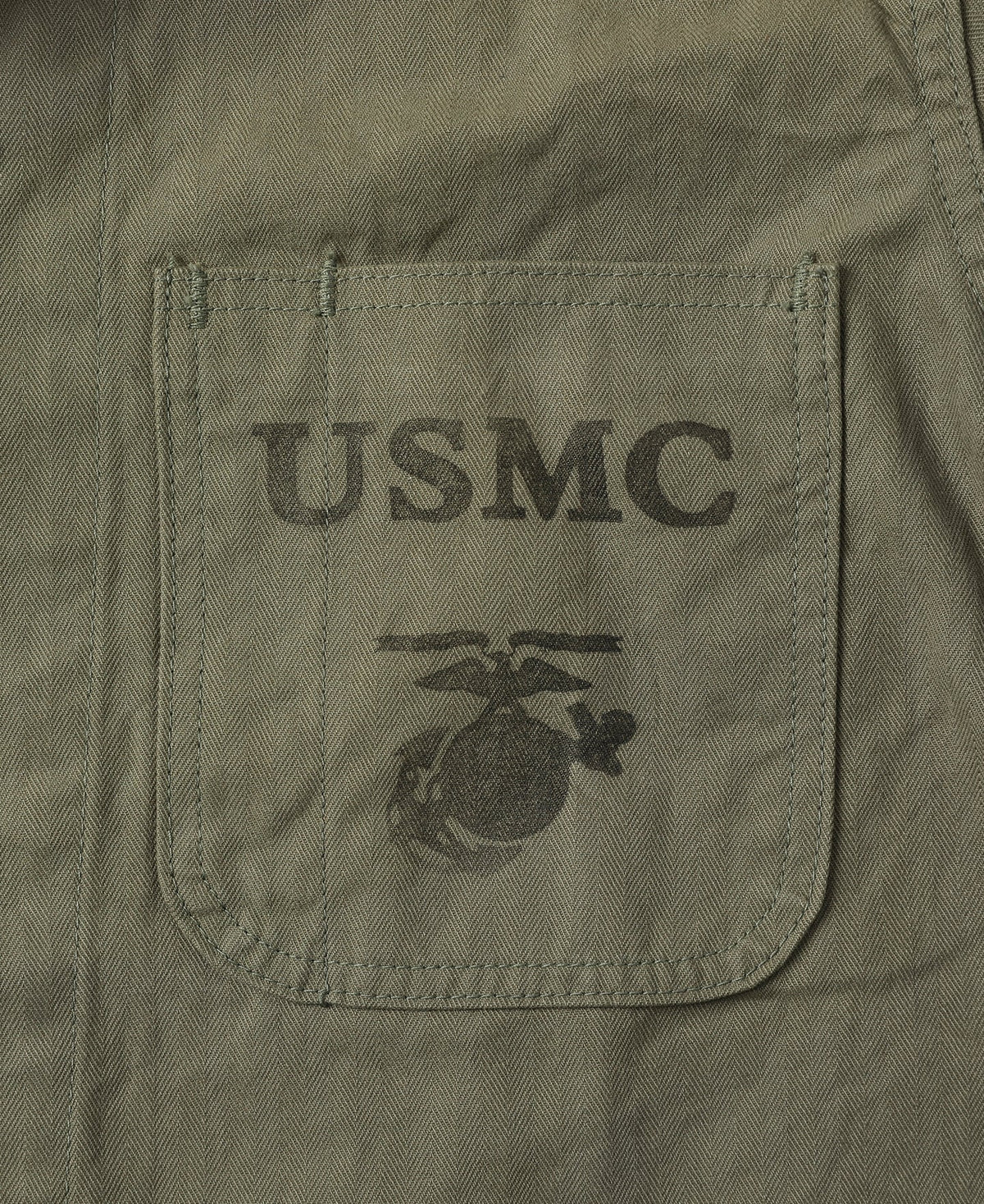 Macro of the chest pocket with the printed military stencil on the herringbone twill