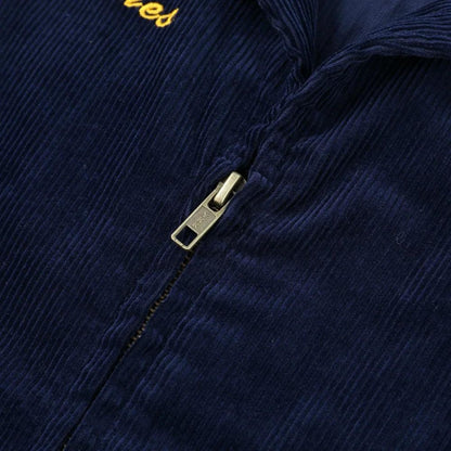 Close-up of the brass YKK zipper and chest embroidery on the Rider Corduroy Jacket in Navy