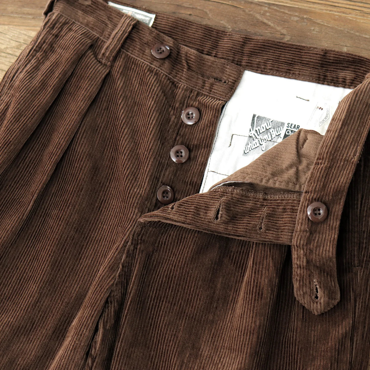 Zip fly with buttoned waistband and printed pocket bag on the Coffee trousers