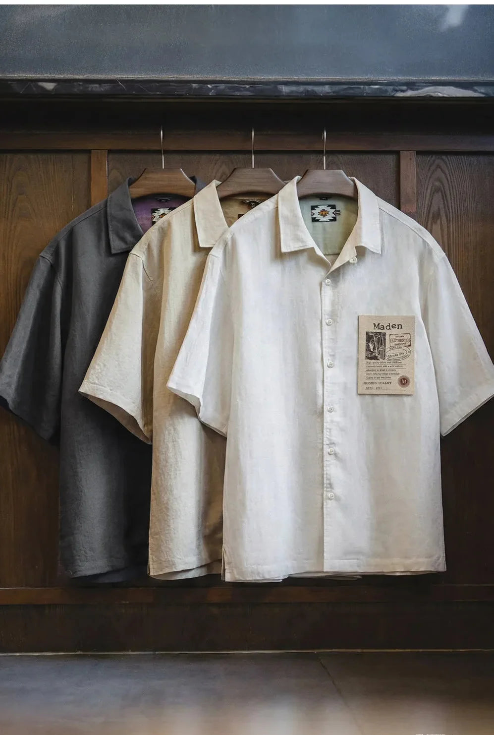 Slate Grey and Ecru shirts hanging side by side in a wooden wardrobe