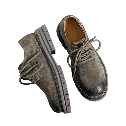 Workshop Suede Derby in Taupe on black, one shoe turned to show the lugged rubber sole
