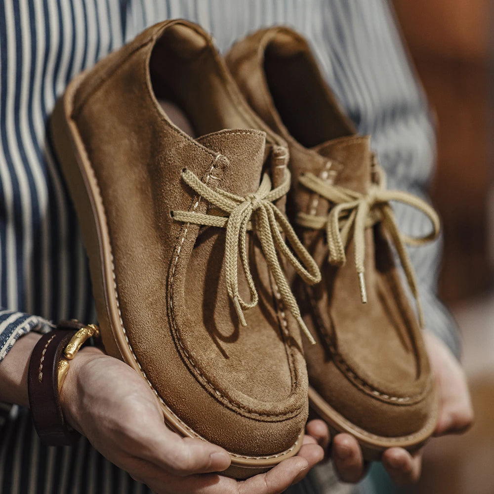 Suede Desert Shoe held in hand, showing the suede and the stitching