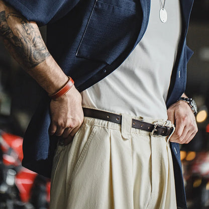 Man wearing the slim belt with pleated trousers and an open navy shirt