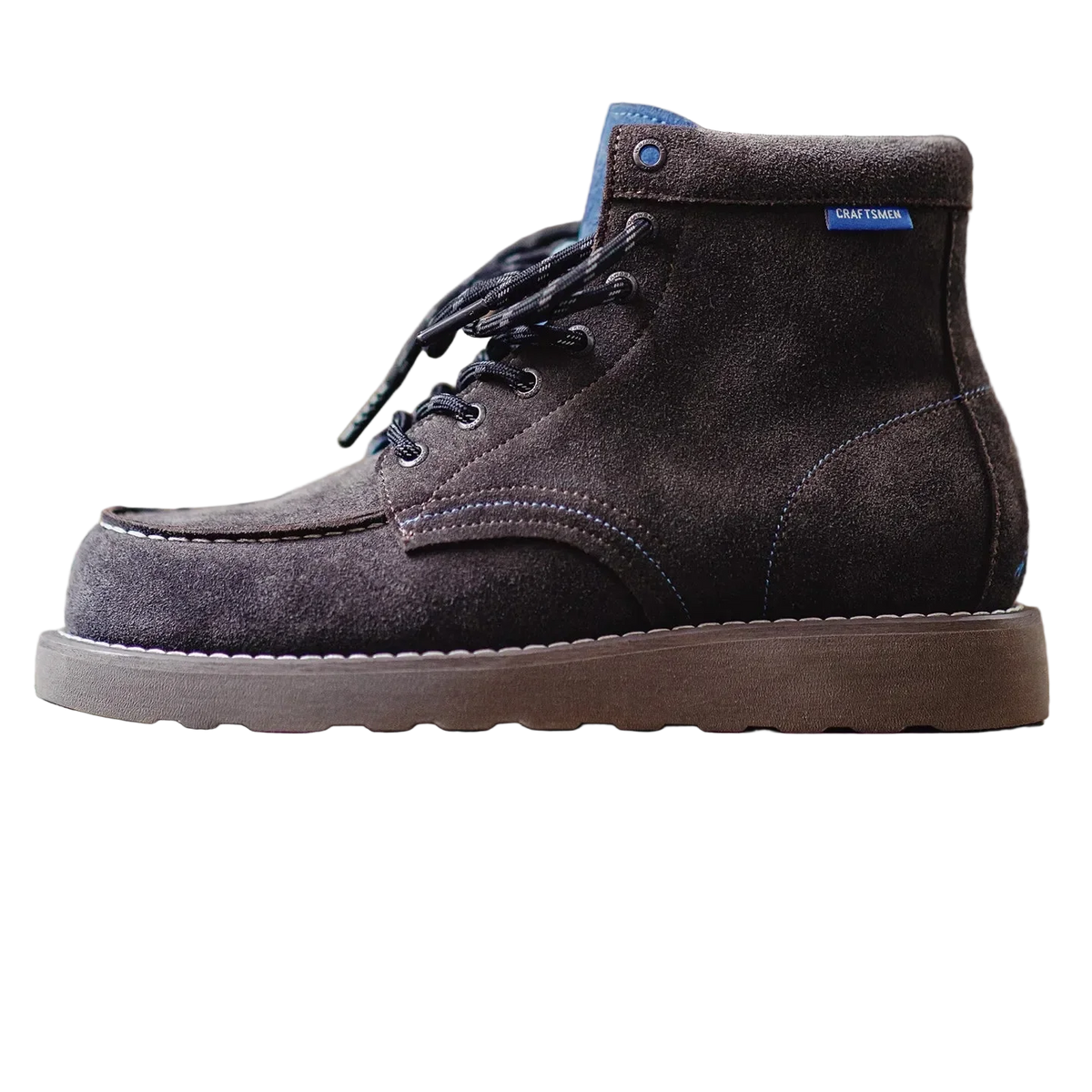 Side profile of the Charcoal Brown moc toe boot showing the rubber sole and blue tongue