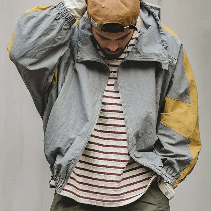 North Wind Nylon Windbreaker in Mist Grey, worn open over a striped tee