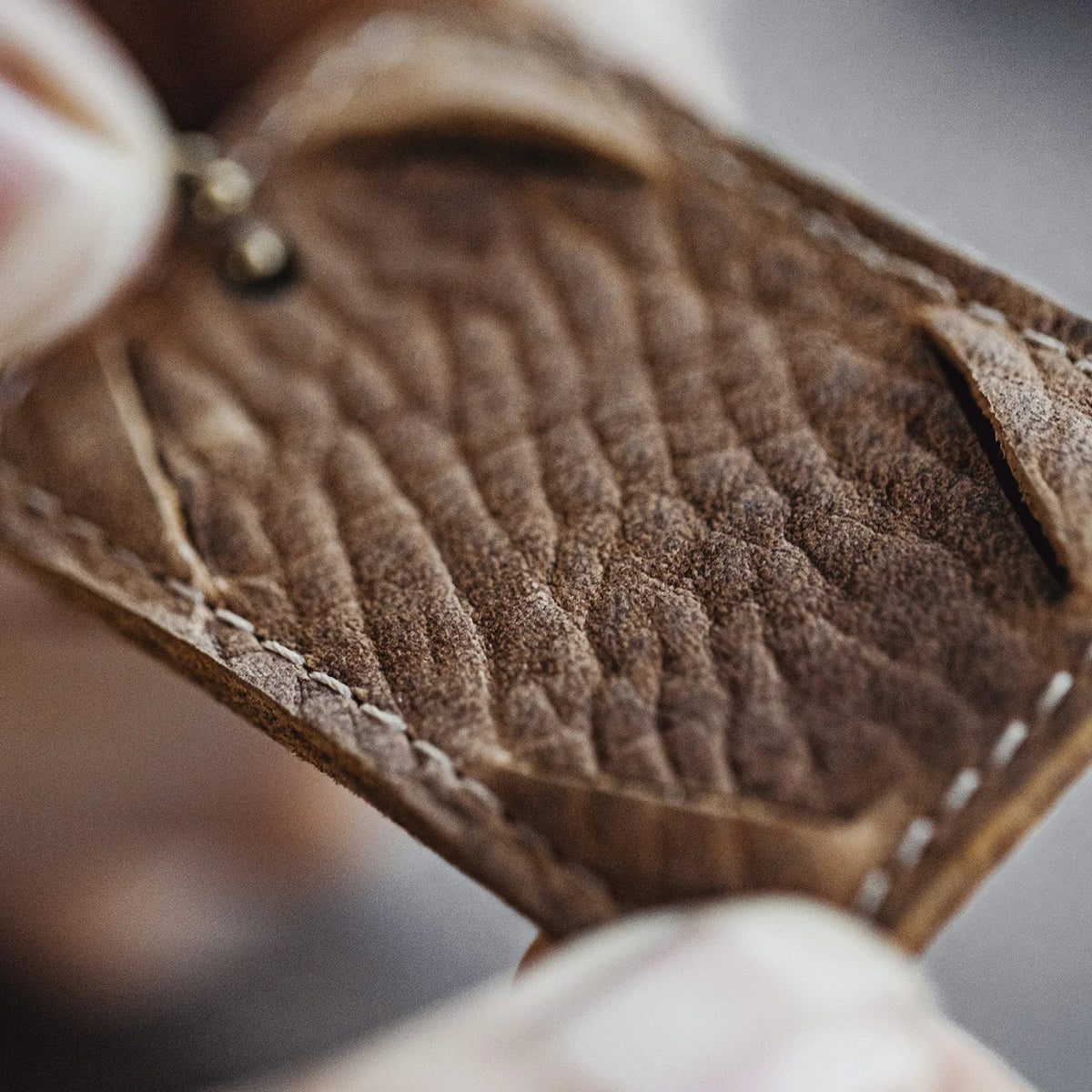 Macro of the full grain leather and light stitching of the tag holder