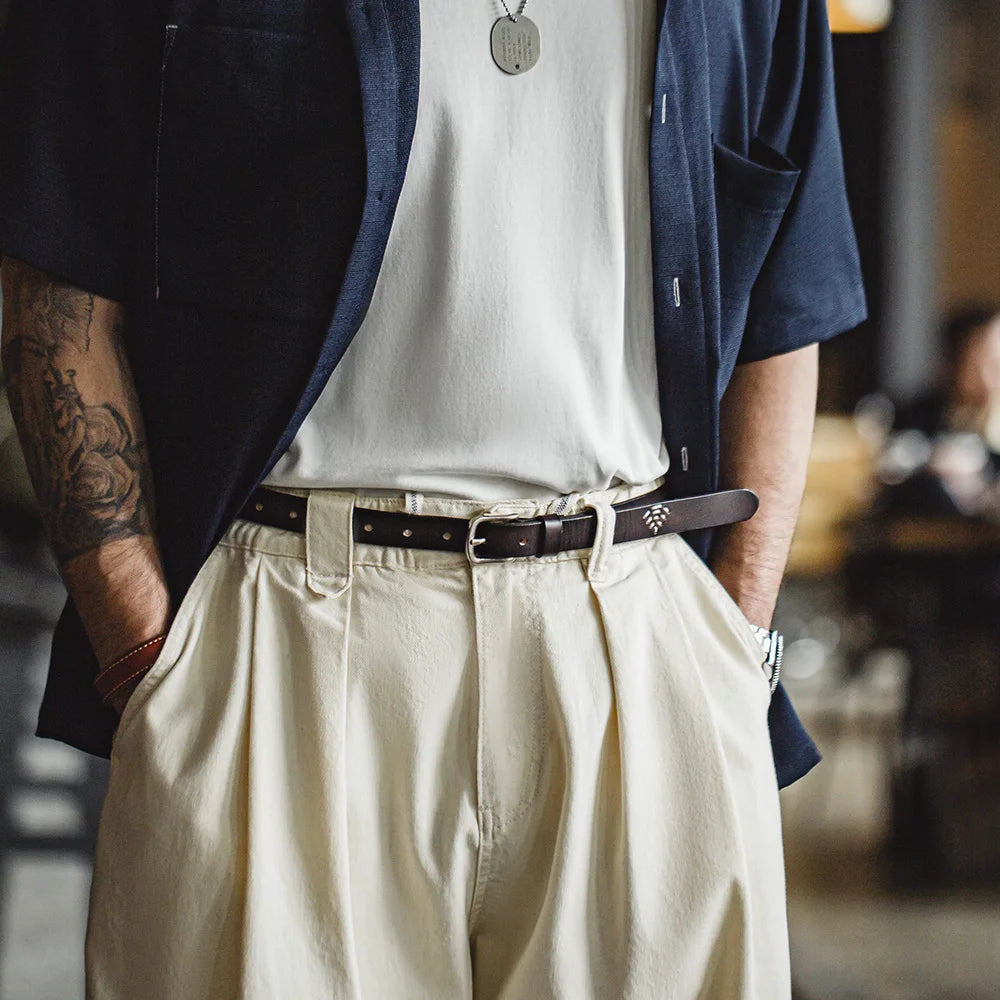 Front view of the belt on pleated trousers, hands in pockets