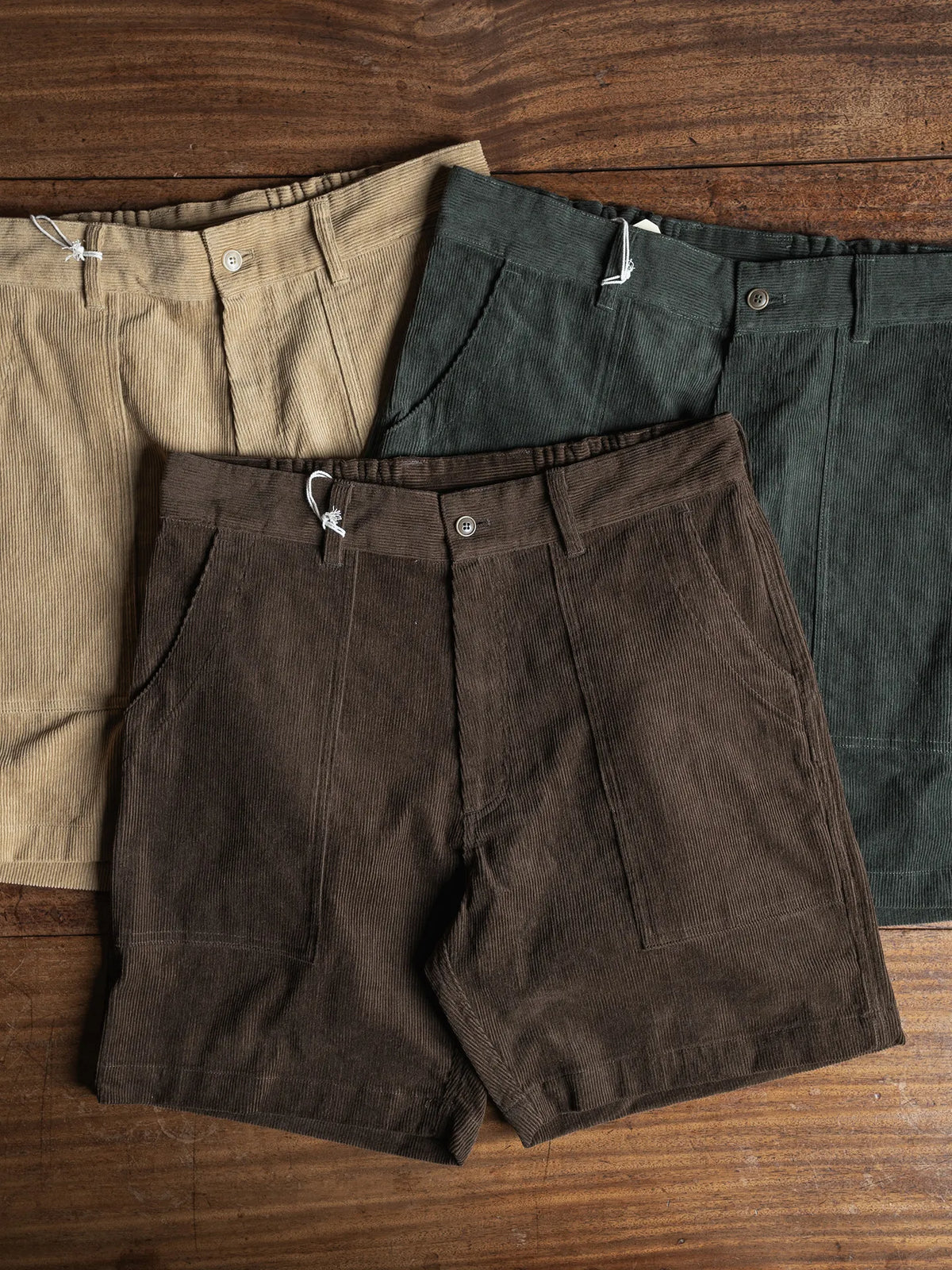 70s Longboard Corduroy Shorts in the three colors on a wooden table