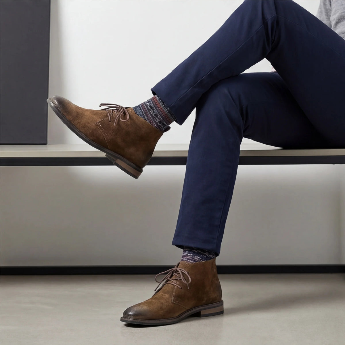 Pampa Suede Chukka Boot with navy trousers, legs crossed