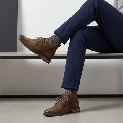 Pampa Suede Chukka Boot with navy trousers, legs crossed