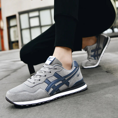Grey and Navy sneaker worn with black pants, crouching on a concrete step