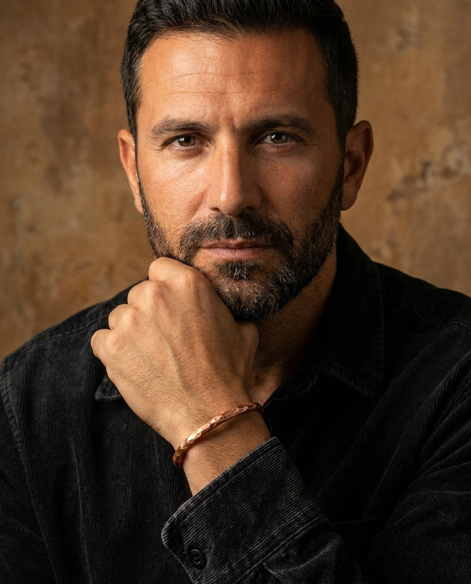 Man wearing the Blacksmith Copper Cuff on the wrist with a dark corduroy shirt