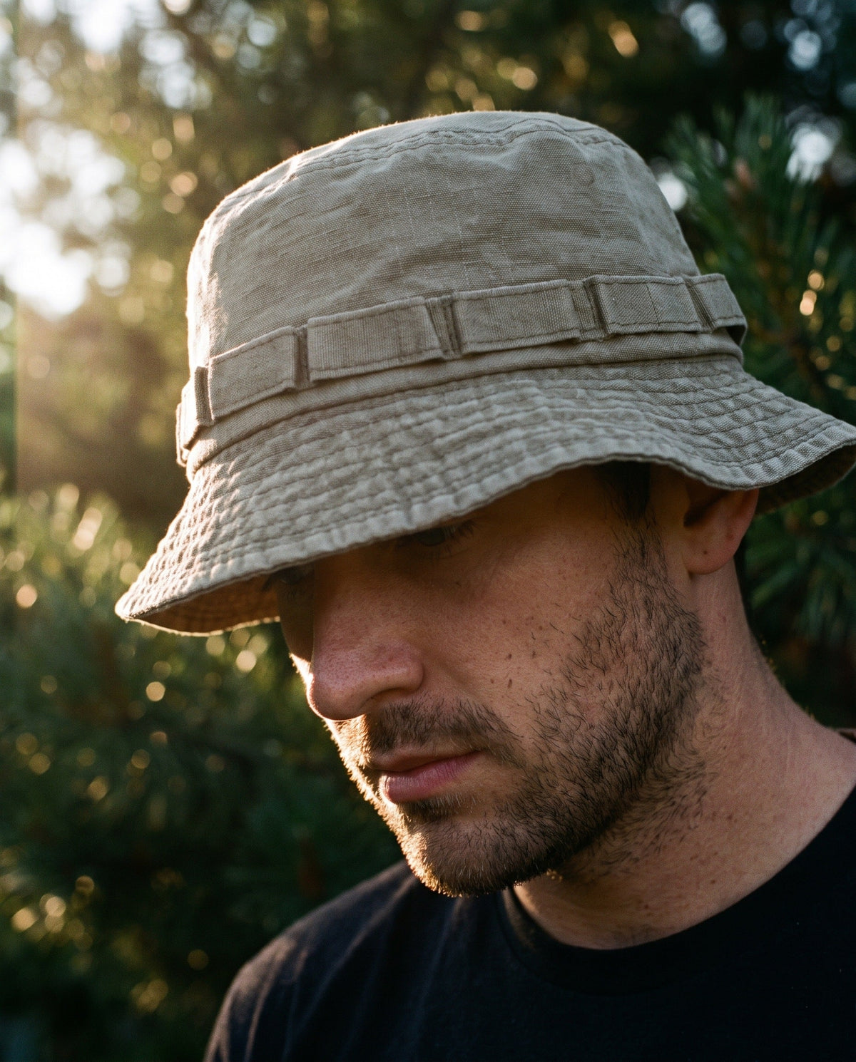 Man wearing the Stone bucket hat among pine trees