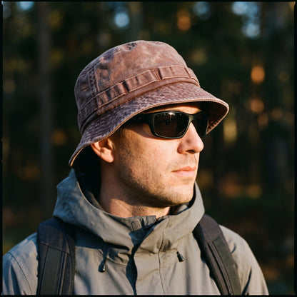 Man wearing the Washed Brick bucket hat with sunglasses in the forest