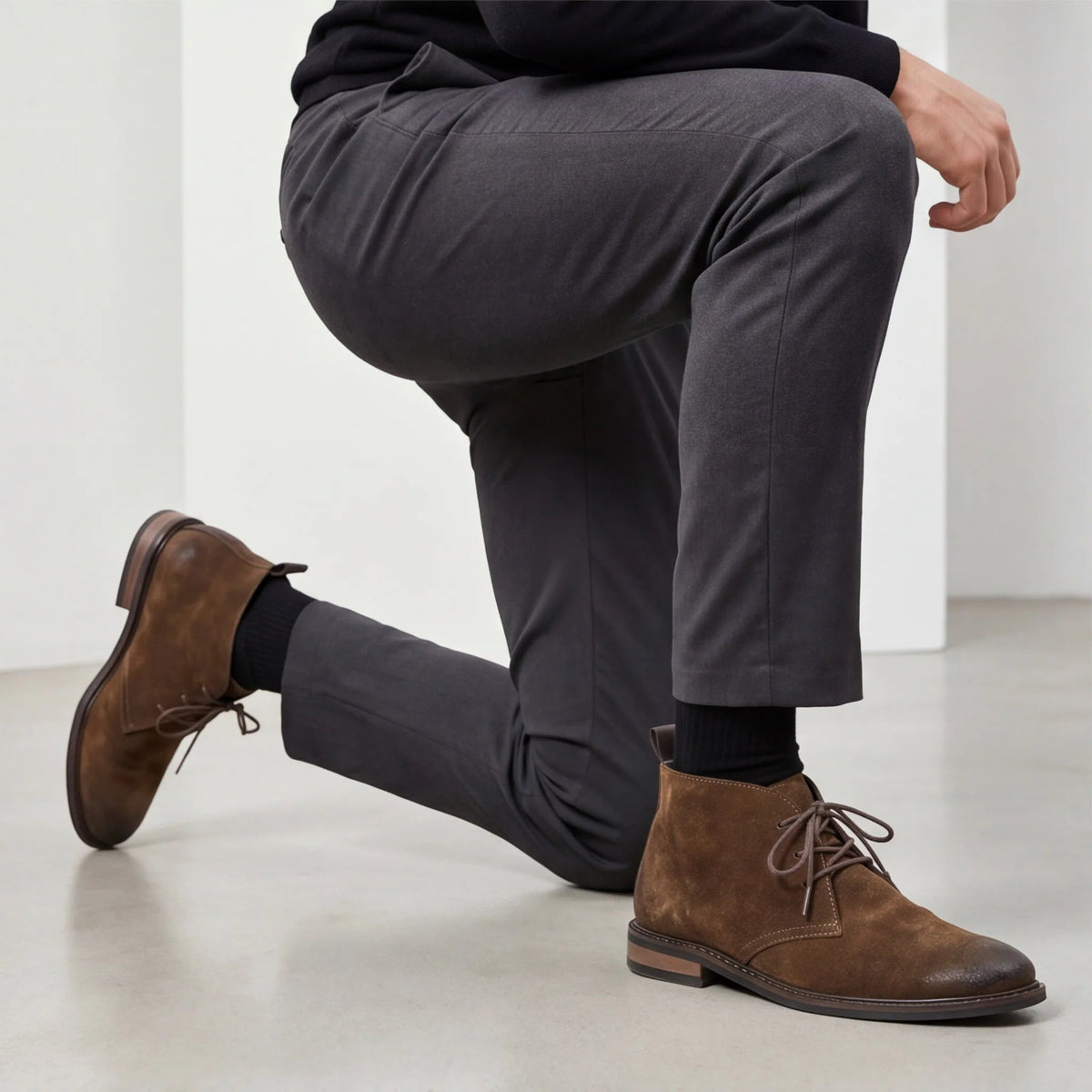 Pampa Suede Chukka Boot with grey tailored trousers, man kneeling