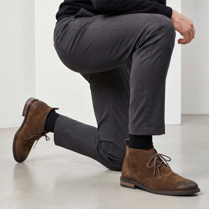 Pampa Suede Chukka Boot with grey tailored trousers, man kneeling