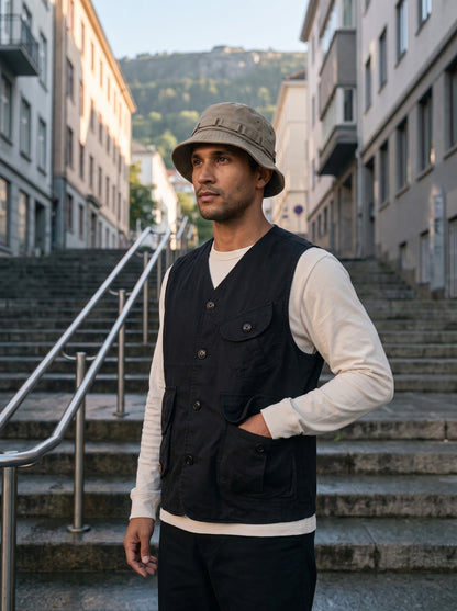Man wearing the Black Expedition Cargo Vest over a long sleeve tee on city steps